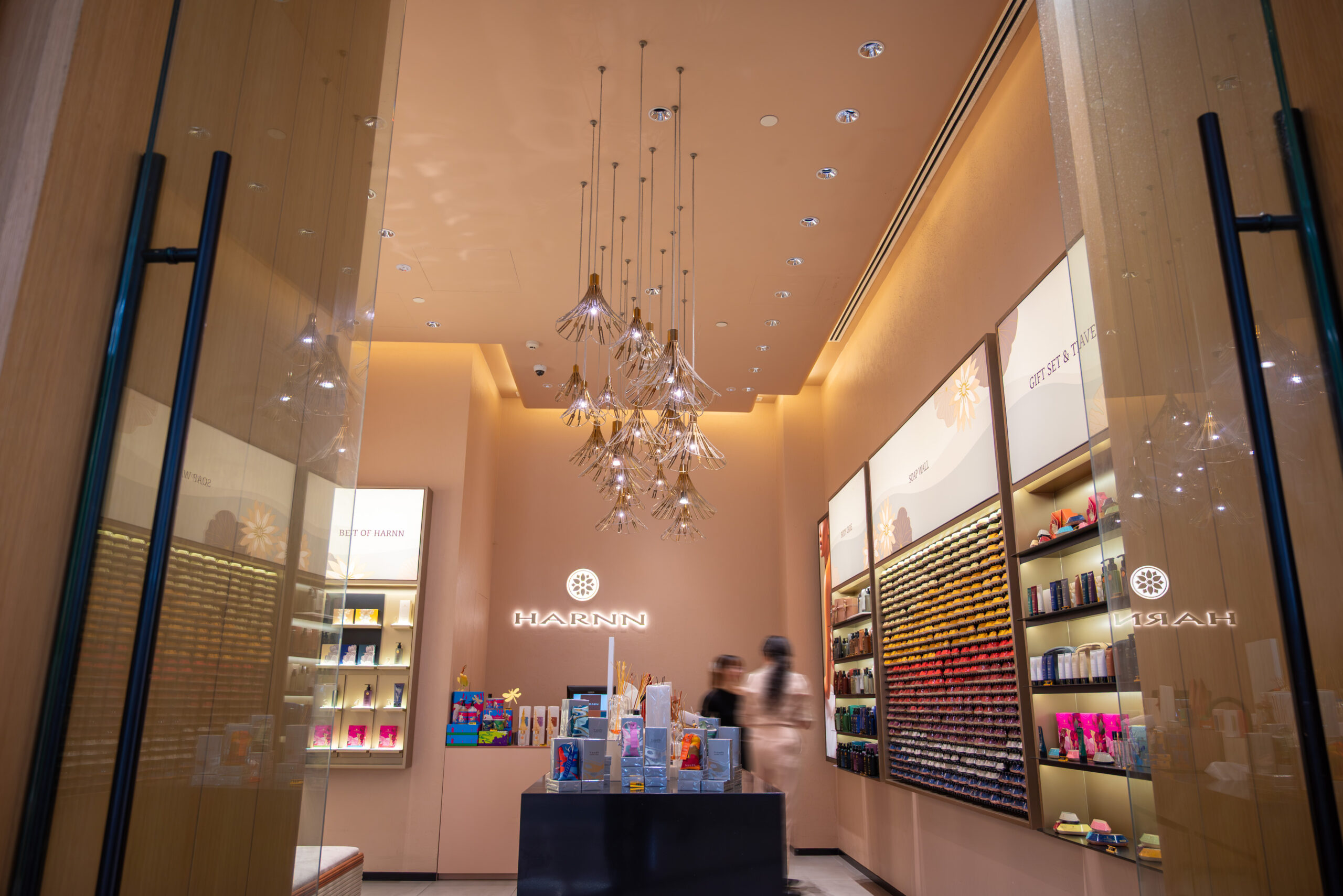 Luxury wellness retail interior with HARNN soap wall and chandeliers
