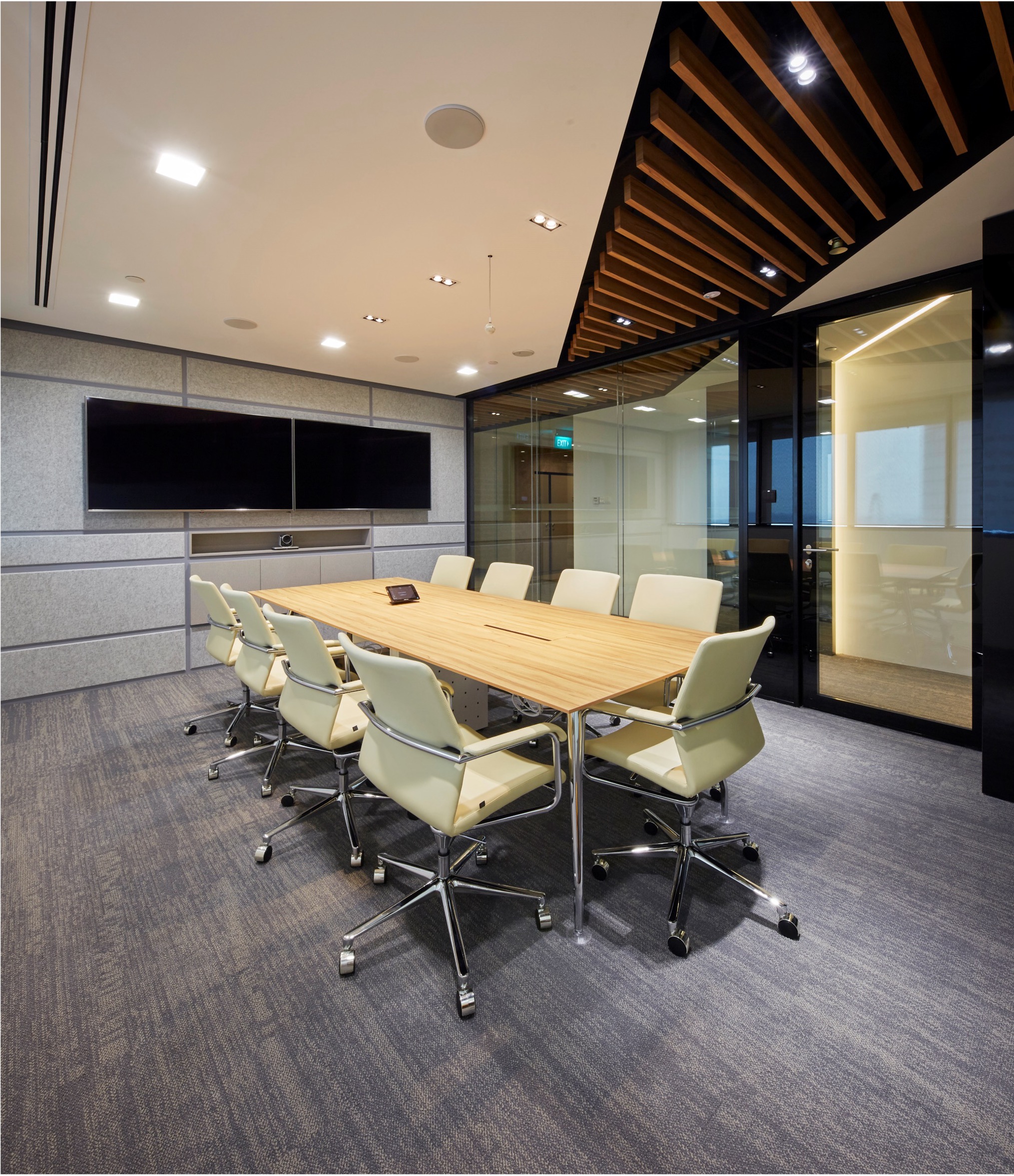 L.E.K. Consulting boardroom with timber meeting table and dual display screens