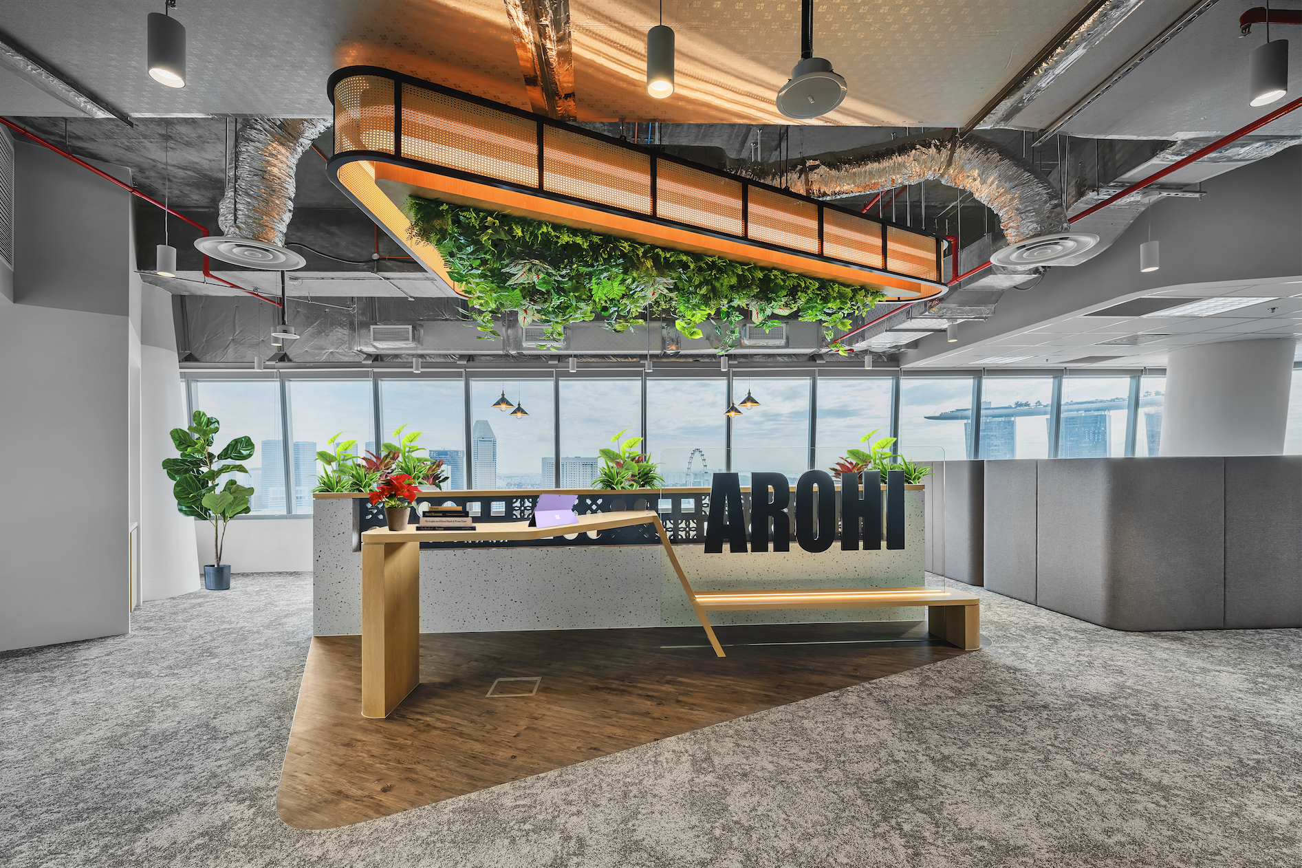 Arohi office entrance with timber feature wall, greenery and Marina Bay views