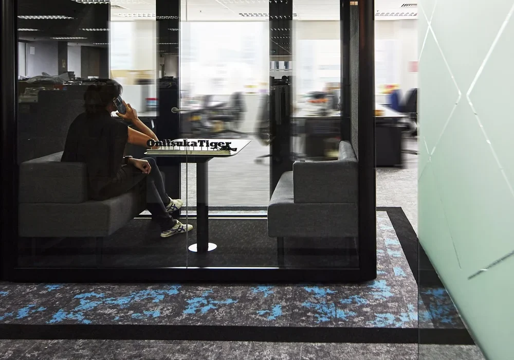 Private ASICS office call pod beside the open-plan workspace