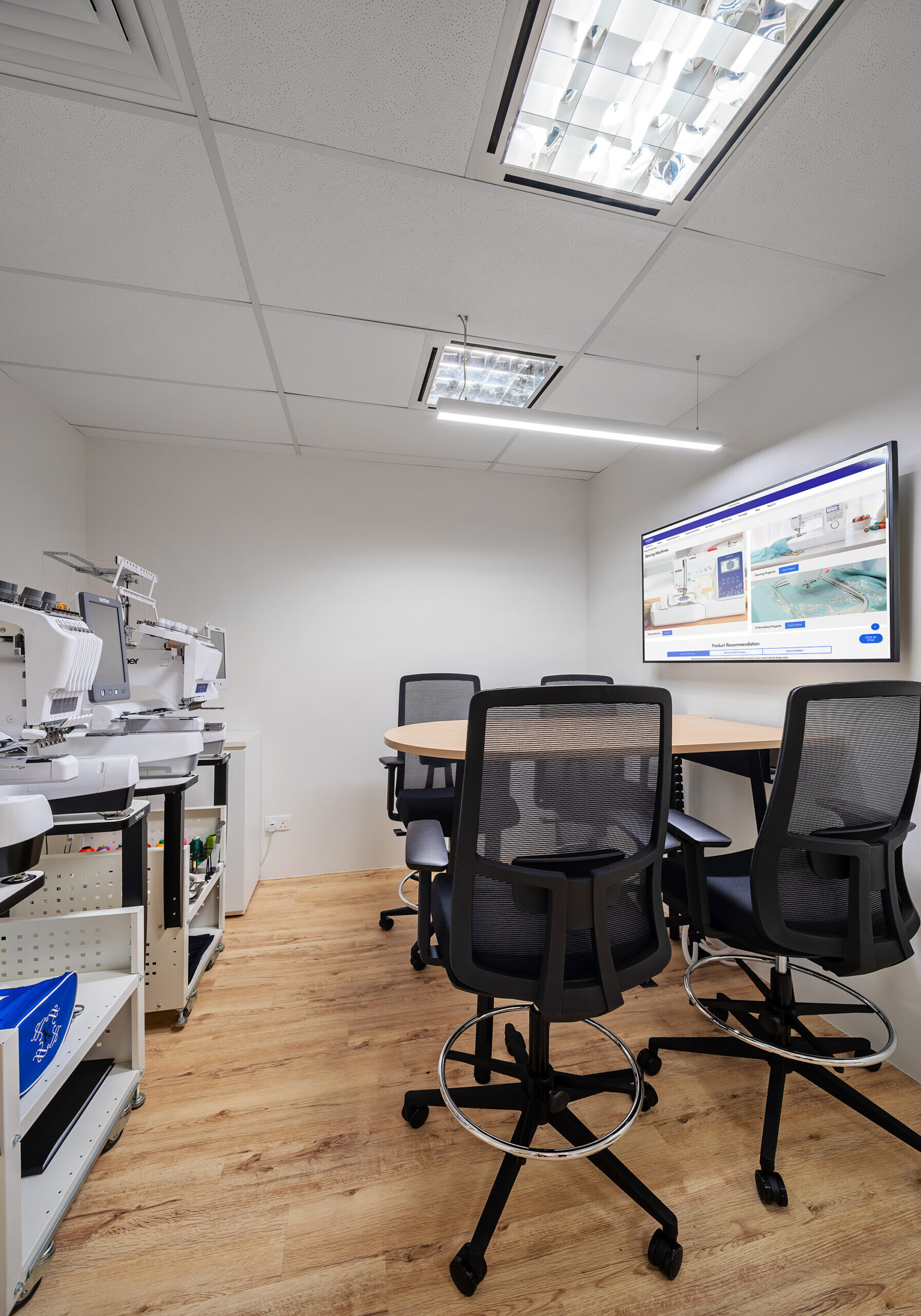 Brother training room with sewing equipment and digital presentation screen