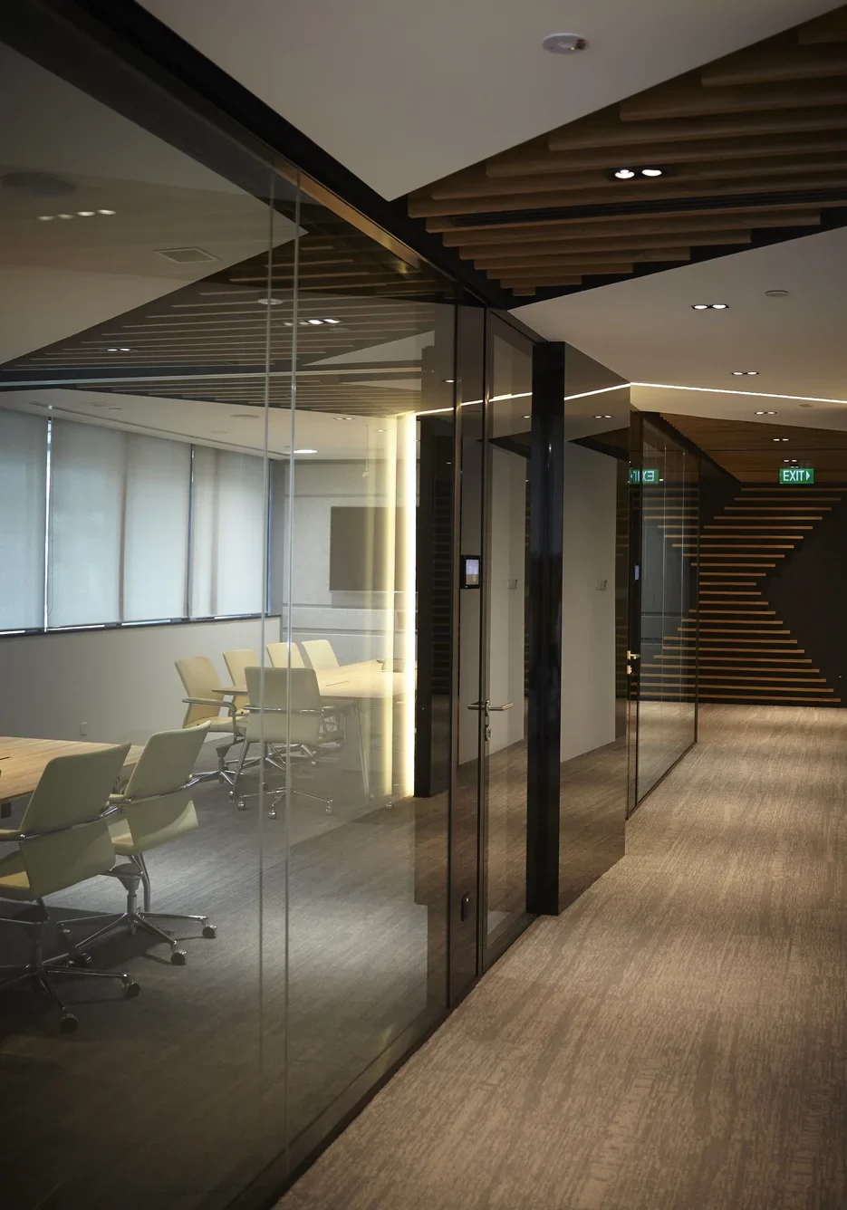 Glass meeting room corridor with diagonal timber ceiling details at L.E.K. Consulting
