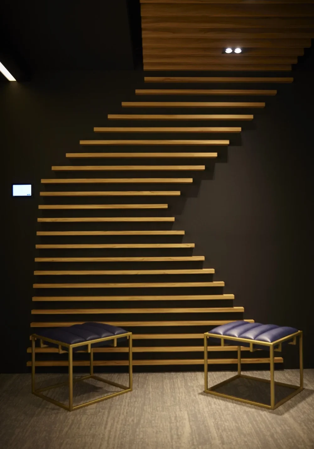 L.E.K. Consulting office waiting area with sculptural timber wall and blue stools