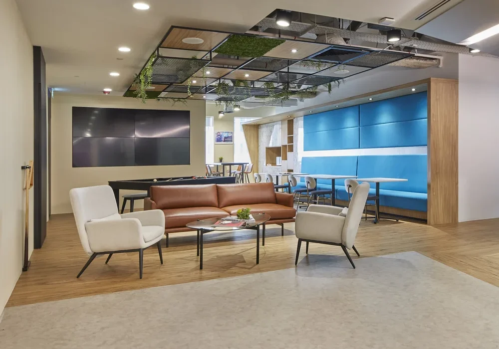 ASICS office breakout area with blue upholstered seating and timber finishes