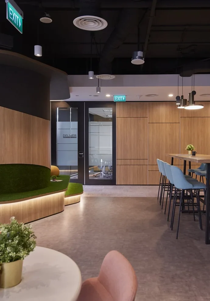 Informal GfK collaboration space with raised green seating and high meeting table