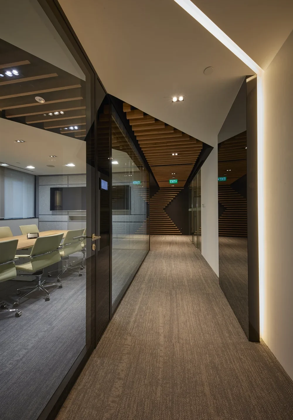 Glass meeting room corridor with diagonal timber ceiling details at L.E.K. Consulting