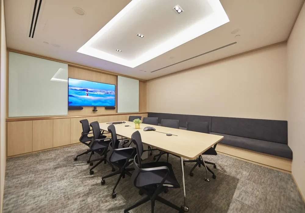Persistent Asset meeting room with presentation screen and upholstered bench seating