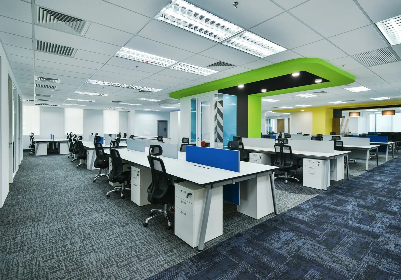 Open-plan Zimmer Biomet workplace with branded green ceiling features